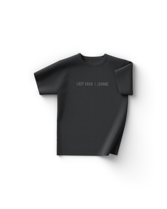 Black Lady Gaga t shirt front view with minimal text "Lady Gaga / Joanne" across the chest