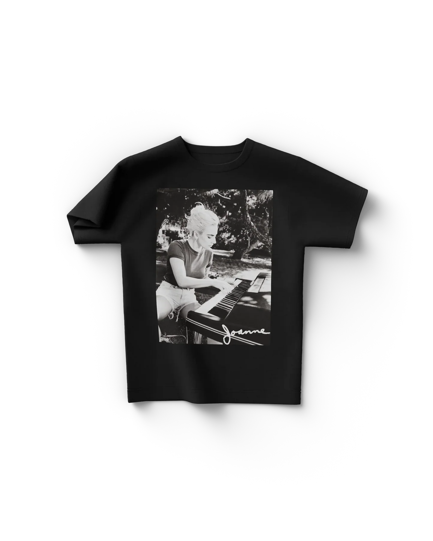 Black Lady Gaga t shirt front view featuring black and white photo of Lady Gaga playing piano with "Joanne" signature text